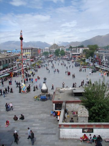 A view overlooking a pedestrian square in Tibet, filled with people.