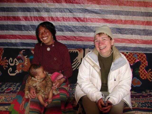 Jacqueline Briggs Martine sitting next to another woman and a baby, who is looking at her.