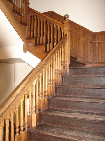 Worn stairs with a carved wooden banister