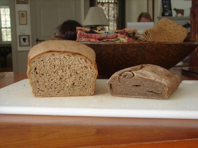 A beautiful loaf of wry bread next to the deflated loaf from earlier.