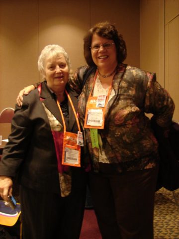 Two women posing at a conference